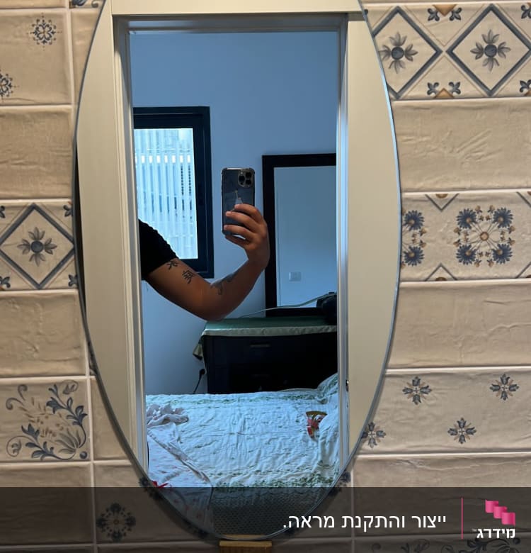 מראה אובלית עם מסגרת לבנה על קיר מעוצב